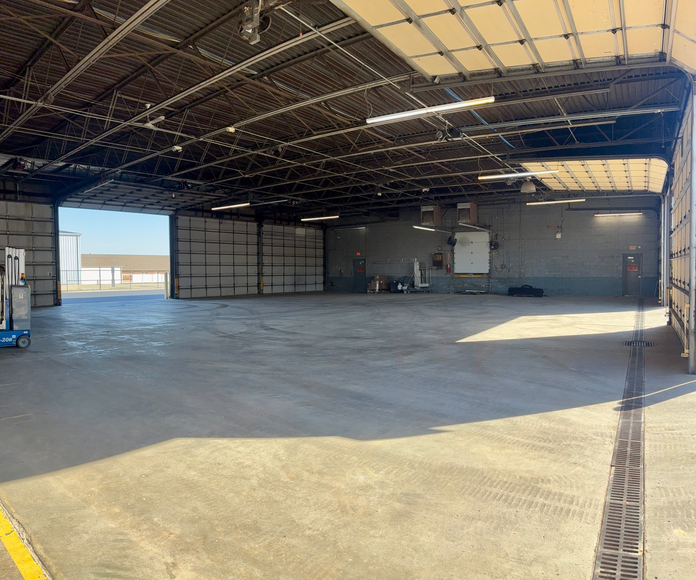 Spacious indoor storage bay with a concrete floor, high ceilings, and multiple large overhead doors