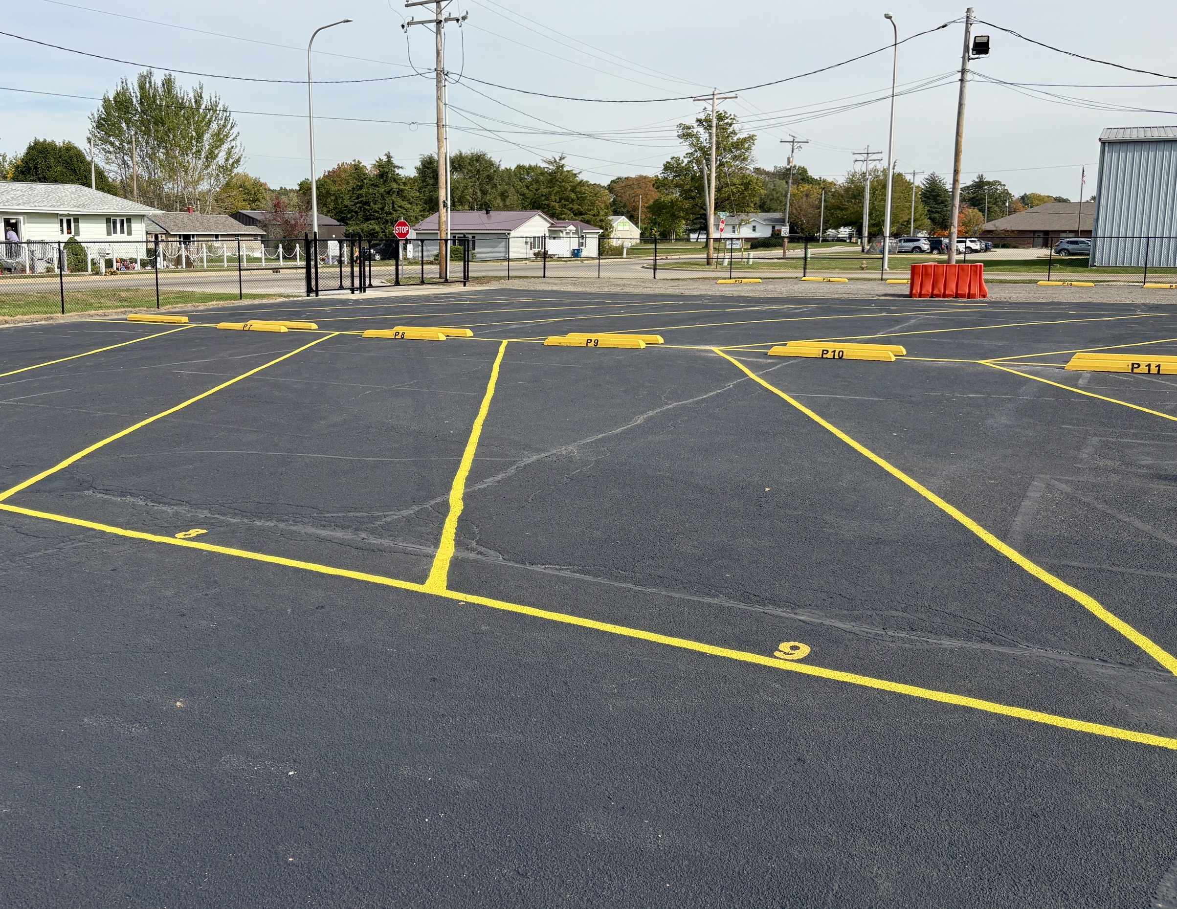 Large striped outdoor parking spaces numbered 8 and 9 with yellow wheel stops labeled P7 through P11