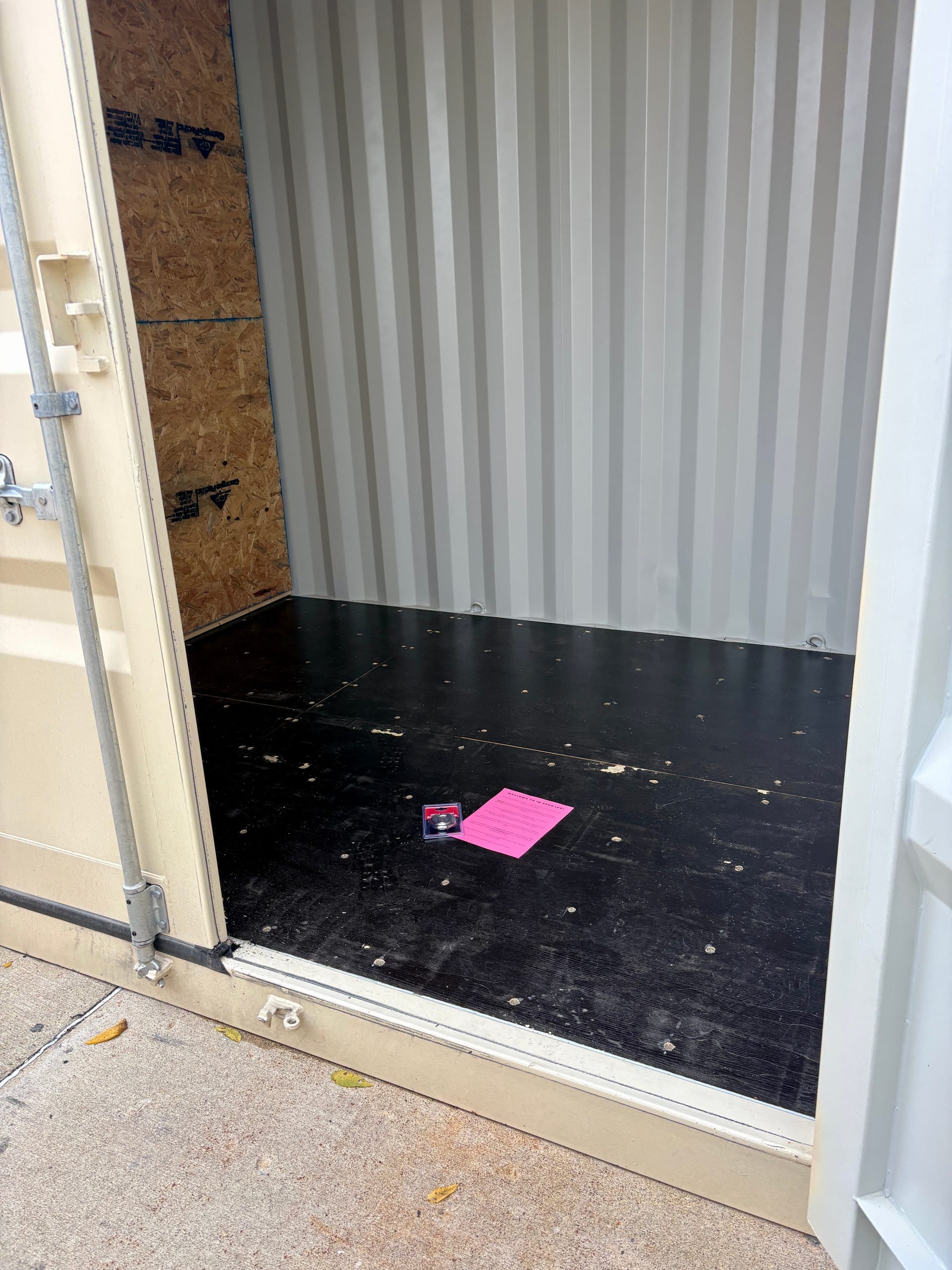 Open 3k Storage unit with a padlock and welcome sheet waiting on the floor